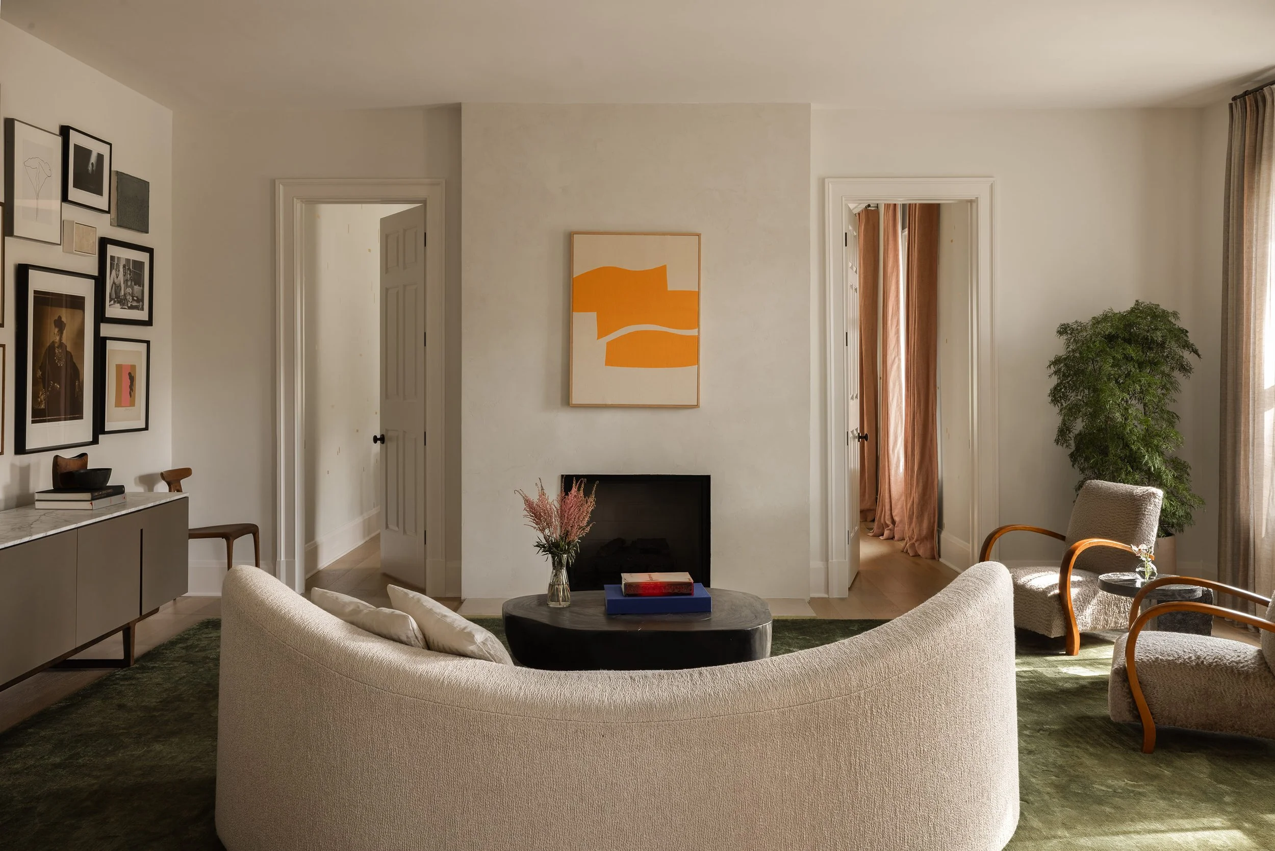 McLean living room with a salon gallery wall, an Ethan Cook painting on the plaster fireplace, vintage chairs, and a Moon sofa from Les Atelier Courbet.